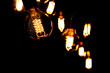 Classic Edisson bulbs backgound. Retro style bulbs. Vintage glowing light bulbs on a black background.