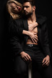 © LIGHTFIELD STUDIOS - young woman embracing sexy man in suit sitting on chair isolated on black