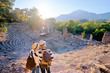© luengo_ua - Travel and tourism. Senior family couple enjoying view together on ancient amphitheatre.