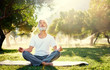 © luengo_ua - Yoga at park. Senior bearded man in lotus pose sitting on green grass. Concept of calm and meditation.
