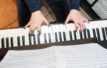 Musician's Female Hands With Manicure And White Black Piano Keys While Playing Music
