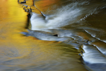 Landscape of the Presque Isle River rapids captured with motion blur and illuminated by reflected color from sunlit cedars, Porcupine Mountains Wilderness State Park, Michigan's Upper Peninsula, USA