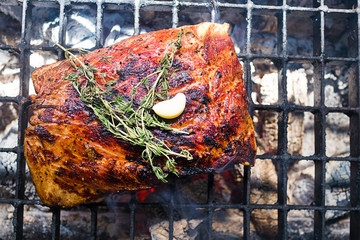 Delicious juicy grilled pork ribs, steak cooked meat on grill. Barbecue, bbq with smoke. Meat cooked, fried on fire with temyan, thyme,  garlic and rosemary. Provencal herbs. Cholesterol concept.