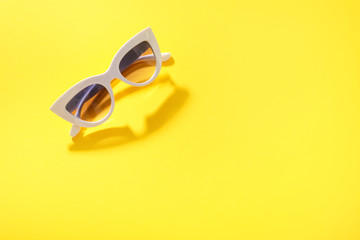 White sunglasses on yellow background