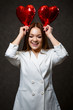 © DSMT - Beautiful girl in a white jacket with a red balloon heart in her hands