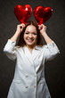 © DSMT - Beautiful girl in a white jacket with a red balloon heart in her hands