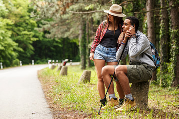 Wall Mural - two friends hiking in nature.they sitting and resting by the old country road.