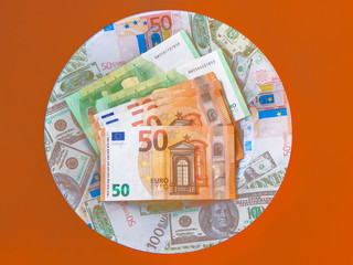 Bank notes on a plate on an orange background