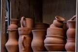 Fototapeta  - a set of ceramic products made of unburned clay standing on a shelf