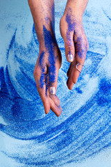 Canvas Print - Abstract blue glitter sparkle background with woman hand. Beauty art concept