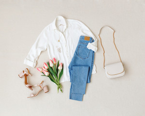 blue jeans, white shirt, heeled sandals, bag with chain strap, jewelry, bouquet of pink tulips flowe