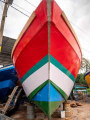 Wall Mural - Closeup image of beautiful colorful painted fishing boat nose in docks at port