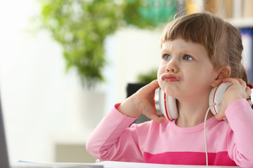 little girl wearing headphones using computer aggressive articulating portrait