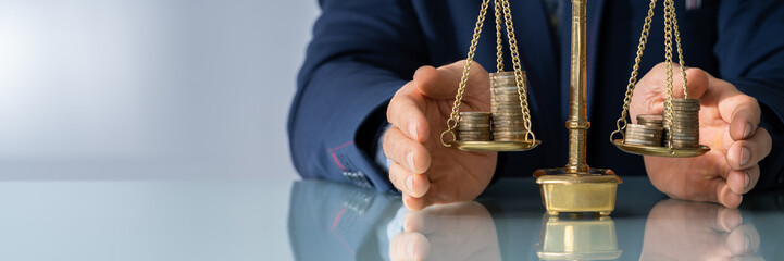 Lawyer's Hand Protecting Justice Scale With Coins