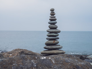 Zen stones on the beach piled by a tower