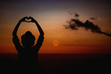 Wall Mural - silhouette of a girl holding heart-shape symbol for love on a starry night sky. my astronomy work.