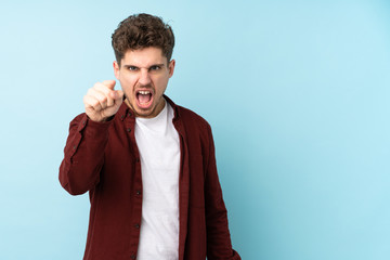 Young caucasian man isolated background frustrated and pointing to the front