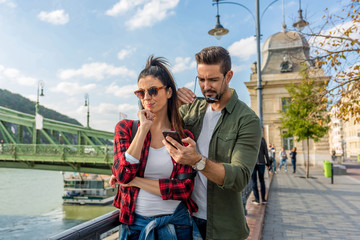 A couple arguing over the content on the mobile phone screen