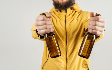 A man shows in his hands two bottles of beer. The concept of an alcoholic party, drunkenness, or advertising.