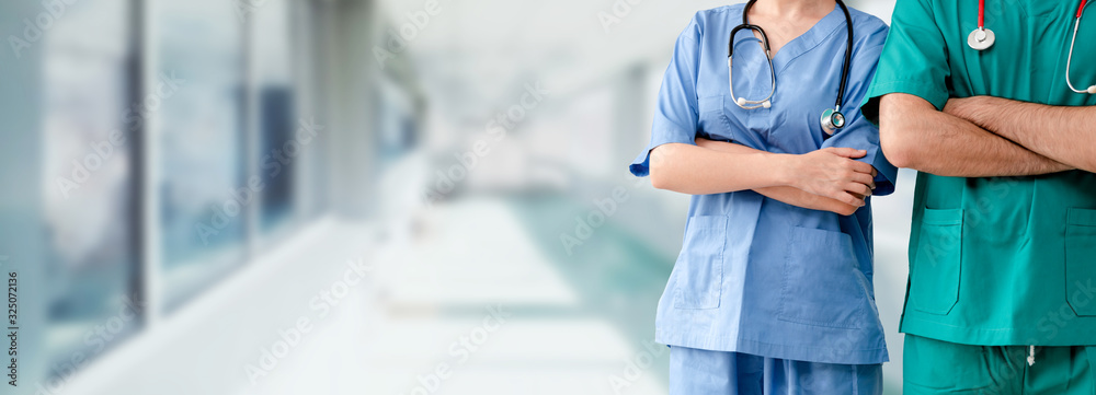 Two hospital staffs - surgeon, doctor or nurse standing with arms crossed in the hospital. Medical healthcare and doctor service. - obrazy, fototapety, plakaty 