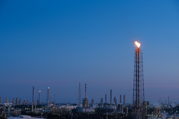 Wall Mural - Flare stack of oil and gas refinery plant and petrochemical industrial estate with blue sky twilight background