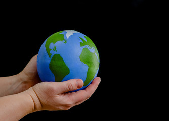 close up woman holds planet in her hands. ecology concept. isolated on dark background. empty space 