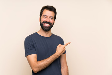 Man with beard pointing to the side to present a product