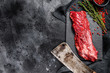 Raw skirt, machete steak with pink pepper and thyme. Black background. Top view. Copy space