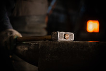 A Hammer On The Anvil In Workshop - A Man Worker Standing On The Background