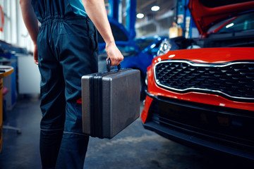 Wall Mural - Worker holds a toolbox, car service station