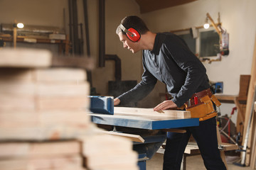 Poster - Professional carpenter working with surface planer in workshop