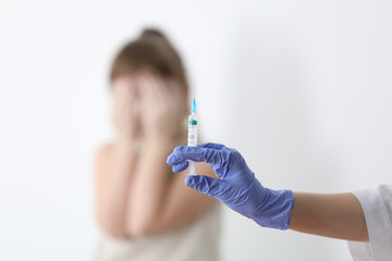 Wall Mural - Doctor holding syringe with chickenpox vaccine and scared child on background, closeup. Varicella virus prevention