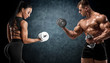 © nikolas_jkd - Sporty couple workout with dumbbells. Muscular man and woman showing muscles