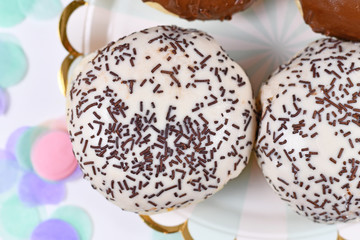 Wall Mural - So called 'Berliner Pfannkuchen', a traditional German dessert similar to doughnut with no hole, made from sweet yeast dough fried in fat glazed with white and brown chocolate and sprinkles