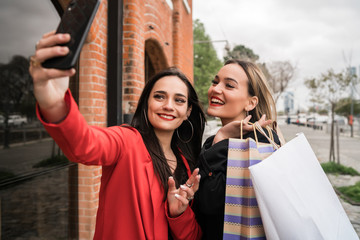 Wall Mural - Two young friends taking a selfie with mobile phone.