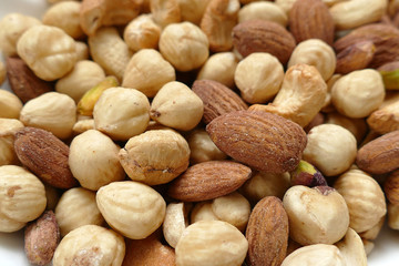 Wall Mural - roasted hazelnuts, almonds and cashews in the same dish,