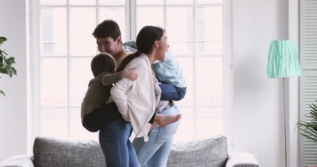 Wall Mural - Active parents playing with children give kids piggyback ride