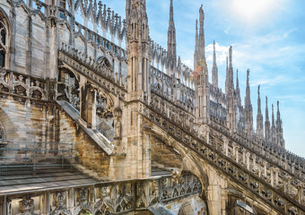 Wall Mural - Milan Cathedral roof, Italy, Europe. Milan Cathedral or Duomo di Milano is top landmark of Milan city. Beautiful Gothic architecture of Milan against blue sky.