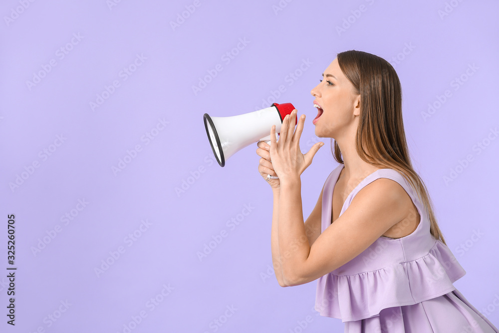 Young woman with megaphone on color background