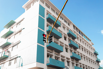 White and aqua mint building with blue sky and a traffic light