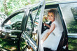 Beautiful blonde bride sitting in the car.