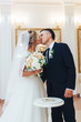 The bride and groom kiss in the room. Classic wedding photography