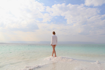 Wall Mural - Woman stands on the Death Sea beach in Jordan