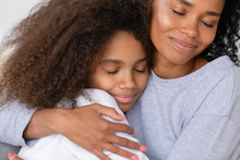 Caring African American Single Mother Hugging Teenage Daughter, Motherhood Concept