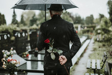 Elegant Sad Elderly Man Standing On The Rain With Umbrella And Grieves At The Grave Of A Loved Person