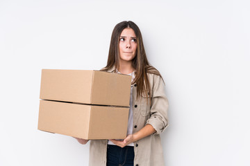 Wall Mural - Young caucasian woman moving to a new home confused, feels doubtful and unsure.