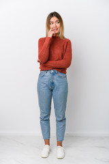 Full body young caucasian woman relaxed thinking about something looking at a copy space.