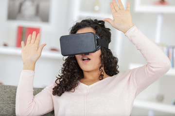 Wall Mural - young woman with virtual reality headset on sofa at home