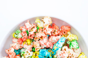 Bol de palomitas de maíz bañadas de azúcar de colores con fondo blanco