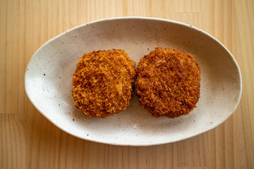 陶器の白いお皿の上のメンチカツ二つ Two ground meat cutlets #4